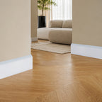Deco plint in wit, modern vlak profiel met schuine bovenkant, langs eiken visgraatvloer