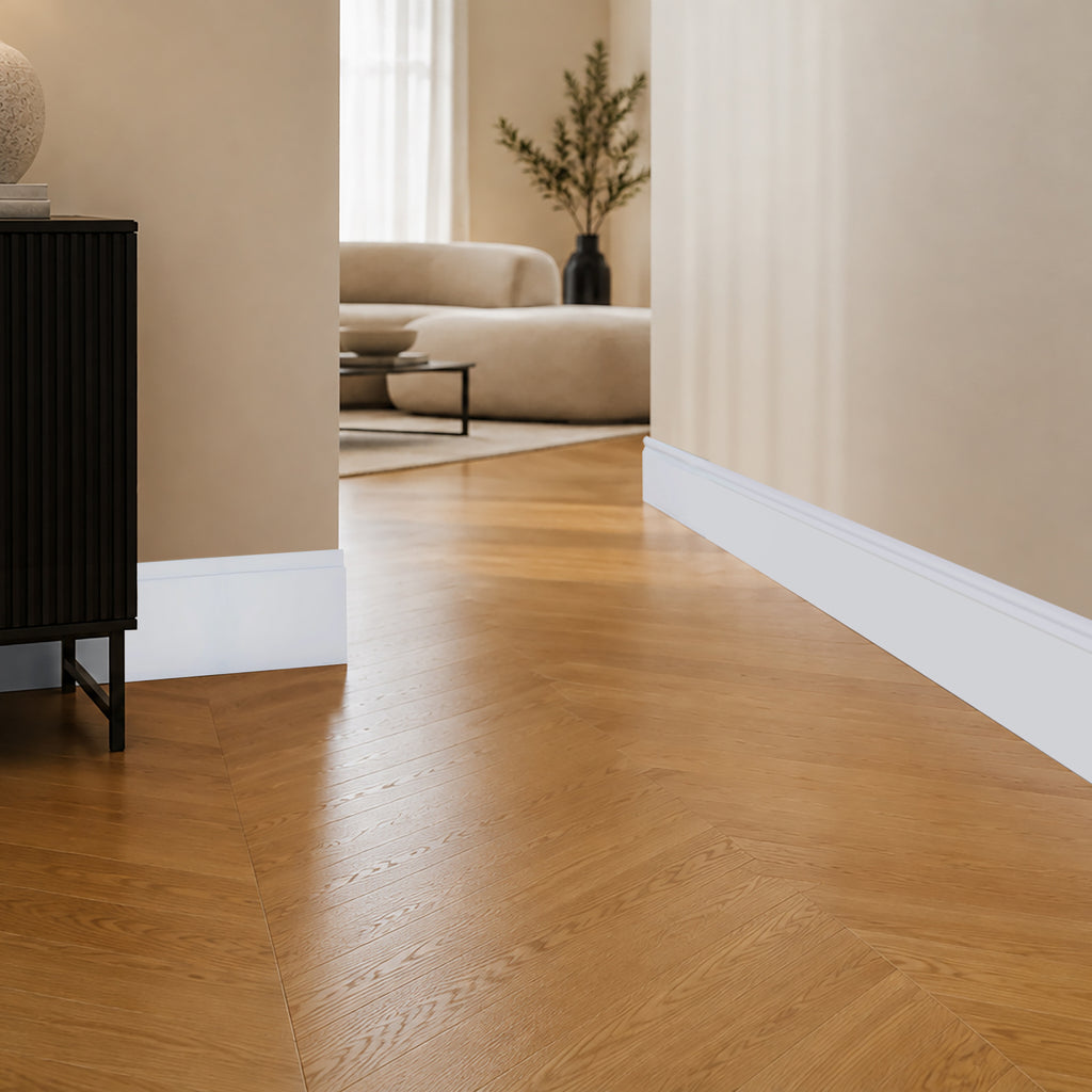 Witte Linea plint in de hal, strak modern profiel met een fijne groef, op eiken visgraatvloer